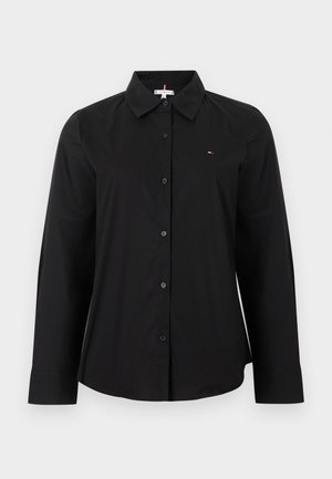Camicia nera a maniche lunghe con bottoni, colletto appuntito e piccolo logo sul petto sinistro, mostrata su uno sfondo semplice.