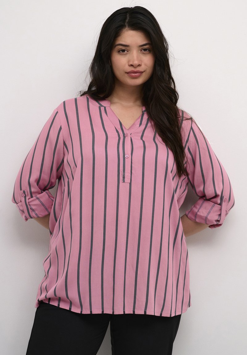 Rosa randig blus med uppvikta ärmar, med en v-ringning och knapprad fram, tillverkad av ett lätt tyg med en mjuk textur.