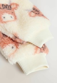 Flauschiger, creme- und hellrosa Pullover mit einer weichen Textur, der mit Tiermustern und weißen Rippbündchen an den Ärmeln versehen ist.