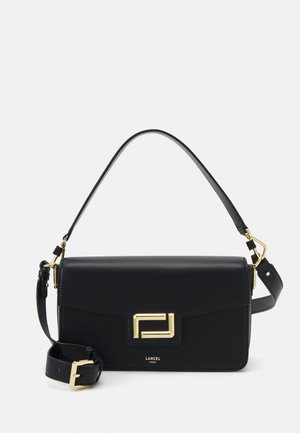 Sac à main en cuir noir avec un design structuré, quincaillerie dorée et une bandoulière amovible. Présente un rabat avant, un logo rectangulaire et une texture lisse.