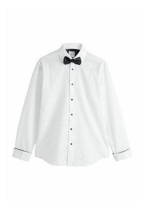 Hvid langærmet skjorte med sorte knapper og sort butterfly. Har en skarp krave og kontrasterende sorte detaljer på manchetterne.