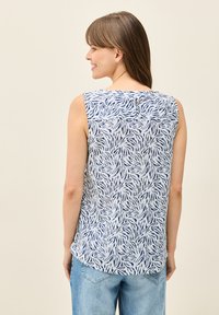 Ärmelloses Oberteil aus hellblauem Stoff mit navyblauem abstraktem Blattmuster. Verfügt über einen abgerundeten Halsauschnitt und ein dezentes Detail am Rückenverschluss.