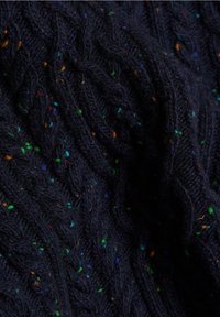 Granatowy sweter z dzianiny, z wzorem w splocie warkoczowym oraz kolorowymi plamkami czerwieni, zieleni i pomarańczy w całej teksturowanej tkaninie.