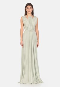 Abito lungo verde chiaro con design plissettato, corpetto senza maniche e vita regolata da una cintura. Presenta una morbida lucentezza e dettagli di texture sottili.