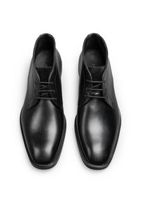 Schwarze Leder-Halbschuhe mit glatter Textur, spitzem Zehenbereich, einem sechslöchrigen Schnürdesign und minimalistischen Nähten.
