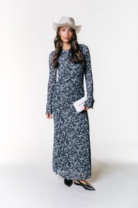 Rochie lungă, bleumarin, cu model alb paisley, mâneci lungi și detalii pliate. Asortată cu un toc alb și balerini negri cu vârf.
