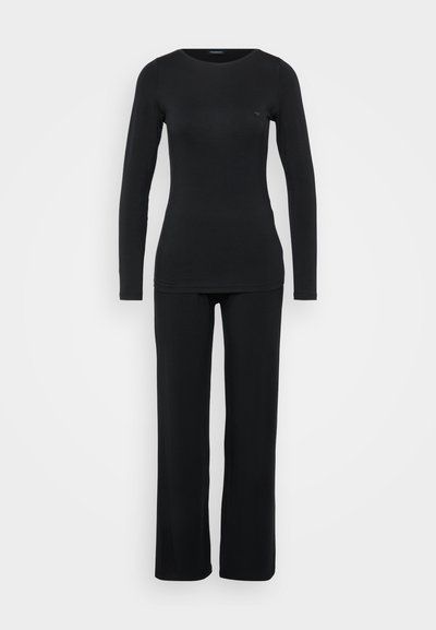 Melns garo piedurkņu tops un atbilstoši plata kāju bikses, abi izgatavoti no mīksta, elastīga auduma. Minimālistisks dizains, bez rakstiem vai aparatūras detaļām.