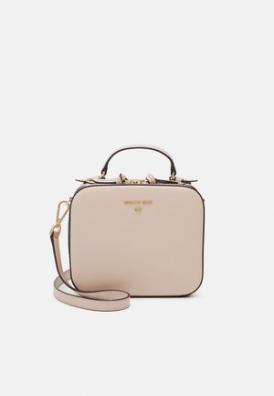 Sac à main carré en cuir beige clair avec une poignée sur le dessus, une bandoulière réglable, une fermeture éclair dorée et le logo Michael Kors sur le devant.