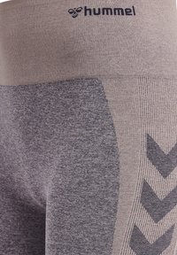 Leggings Hummel en una mezcla de taupe claro y gris oscuro, con una cinturilla texturizada y un panel lateral con un patrón de espiga.