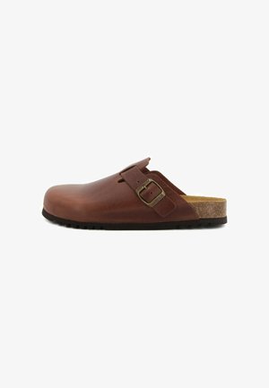 Clog in pelle marrone con finitura liscia, cinturino laterale con fibbia in metallo, suola intermedia in sughero e suola esterna in gomma nera testurizzata.