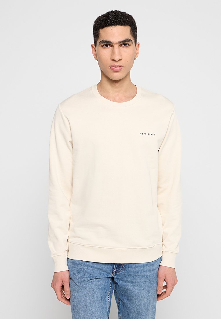 Cremefarbener Kapuzenpullover mit rundem Ausschnitt und langen Ärmeln, aus weichem Stoff gefertigt, mit kleinem Logo auf der Vorderseite.