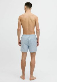 Lichtblauwe zwemboxers van lichtgewicht materiaal, met een elastische tailleband, een enkele achterzak en een gladde textuur.
