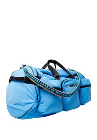 Sac de voyage bleu rembourré avec des poignées noires et une sangle tissée multicolore complexe. Comprend plusieurs poches extérieures et une surface texturée.