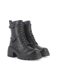 Botas de tobillo negras, con cordones, hechas de cuero suave. Presentan una plataforma gruesa, detalles de hebillas y una suela de goma texturizada.