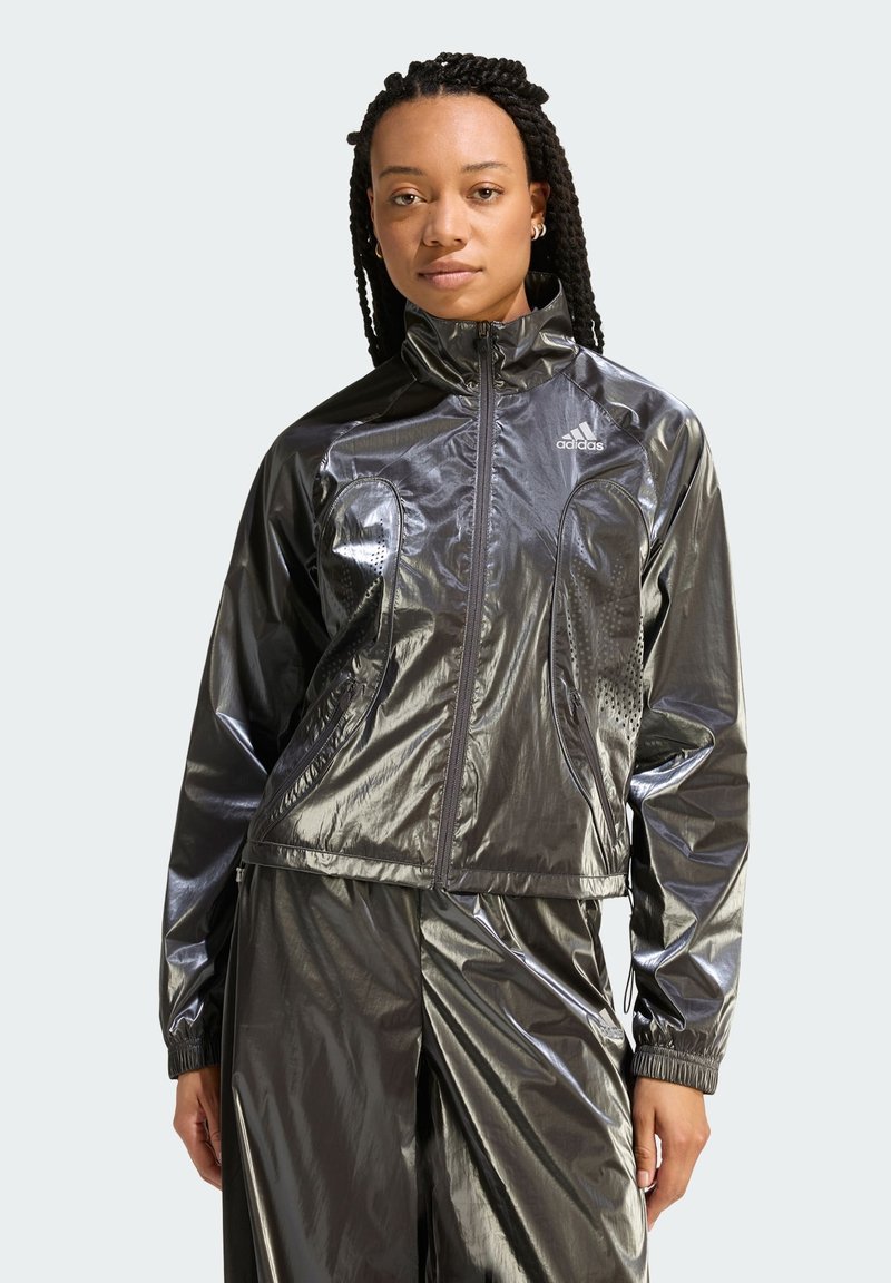 Shiny black track jacket with a high collar, front zipper, and perforated accents. Features elastic cuffs and a fitted design.