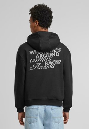 Black hoodie with a large graphic in white text on the back. Features a drawstring hood and ribbed cuffs and hem. Casual fit.
