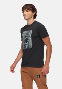 Zwarte T-shirt met korte mouwen van katoen, voorzien van een contrasterende grafische print van een mammoet en tekst binnen een vierkant kader.