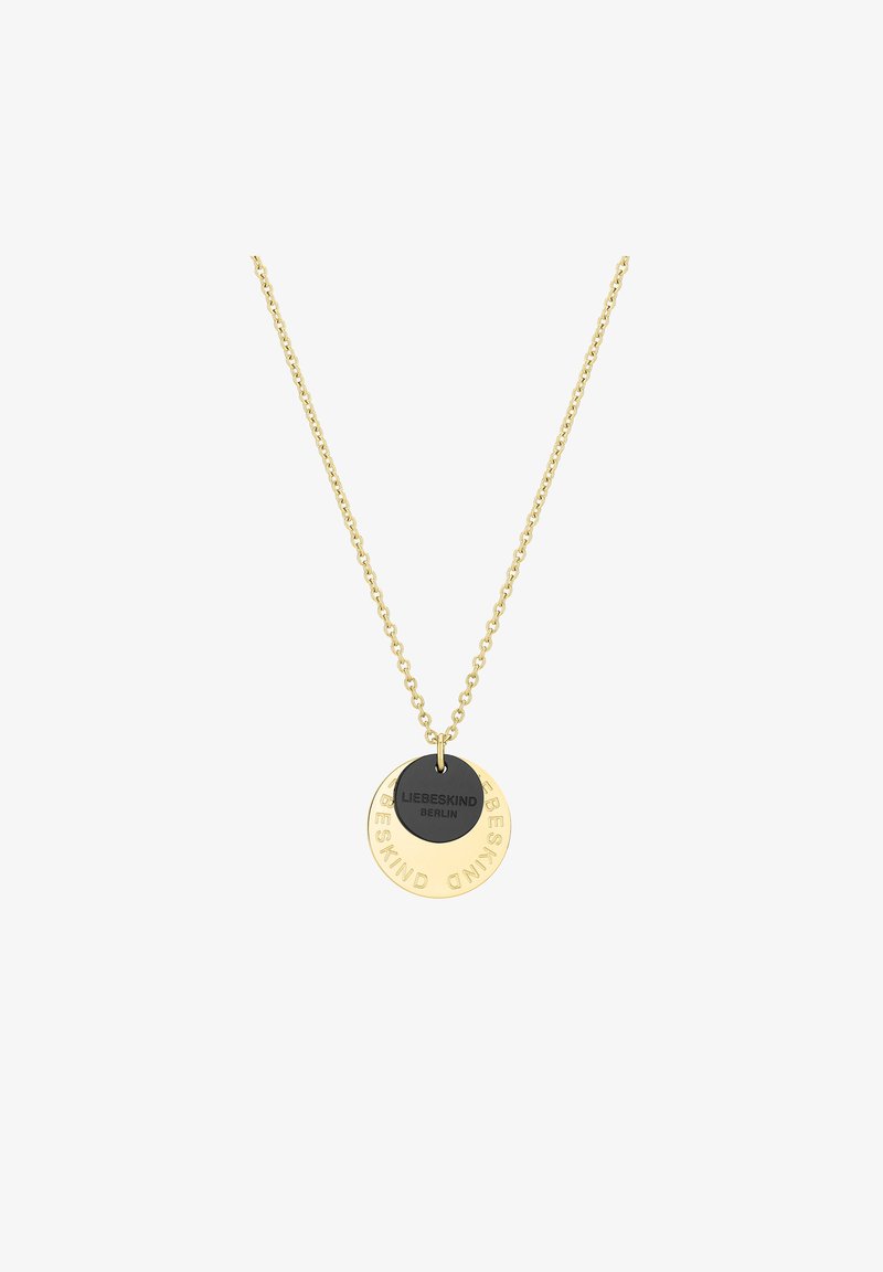 Collier en chaîne dorée avec deux pendentifs ronds : un noir avec un gravure et un doré avec un texte en relief. Design simple, esthétique moderne.