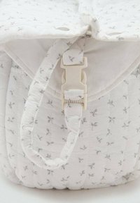 Quilted white bag with small grey floral pattern, featuring a side strap and a plastic buckle closure. Smooth texture and rounded shape.