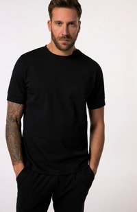 Černé tričko s krátkým rukávem vyrobené z bavlny, s kulatým výstřihem a uvolněným střihem. Tkanina se zdá hladká s mírným leskem.