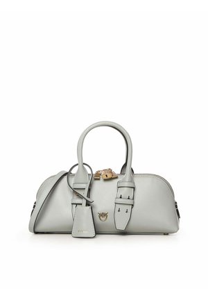 Lichtgrijze leren handtas met dubbele bovenhandgrepen, een klep met gesp, een hangslot en een afneembare riem op een witte achtergrond.