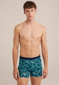 Herrens kalsonger med en mörk teal-bakgrund och ett ljusgrönt bladmönster, elastisk midja och en åtsittande design för komfort.