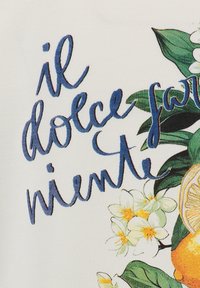 Tessuto bianco con stampa floreale, con fiori arancioni e gialli, foglie verdi e un testo ricamato blu che recita "il dolce farniente."