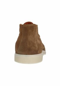 Botte de cheville en suède marron avec une finition texturée, bout rond et semelle en caoutchouc blanc. Dispose d'une doublure intérieure lisse.