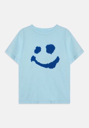 Hellblaues T-Shirt mit kurzen Ärmeln und einem flauschigen dunkelblauen Smiley-Design auf der Vorderseite, das zwei Augen und einen gebogenen Mund zeigt.
