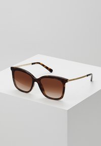 Tortoiseshell sunglasses with a squared frame, gradient brown lenses, and gold-tone metal accents on temples. Brand name displayed on frame.