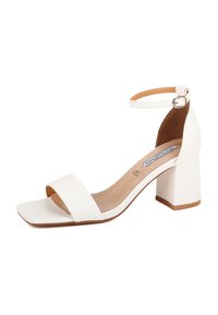 Sandal con tacco quadrato bianco, con punta quadrata, ampia fascia frontale e cinturino alla caviglia con fibbia metallica. Texture simile alla pelle liscia.