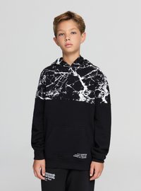 Czarna bluza z kapturem z białym marmurowym wzorem na kapturze i górnej części, z przednią kieszenią i detalem tekstowym przy dolnym brzegu.