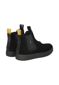 Stivaletti alla caviglia in suede nero con suola in gomma nera texturizzata. Presentano linguette di estrazione gialle e nere, con logo sui lati.