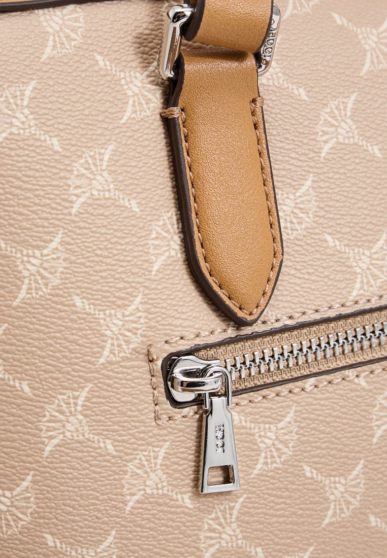 Beige Handtasche mit einem gemusterten Oberfläche, Lederakzenten, einem silbernen Reißverschluss und einer strukturierten Oberfläche sowie einem abnehmbaren Tragegurt.