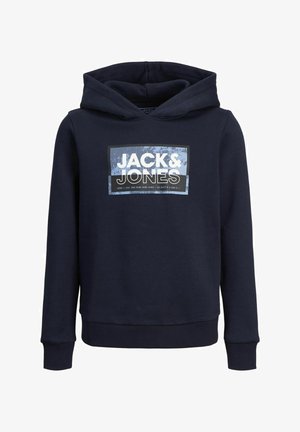 Hoodie bleu marine avec logo sur le devant, en matériau en coton, avec des poignets côtelés, associé à un pantalon bleu marine assorti et des baskets blanches. Design simple et décontracté.
