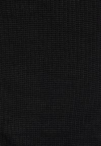 Tessuto di maglia nera con superfice ruvida e testurizzata. Motivo uniforme di filati intrecciati, che offre un aspetto solido e opaco.