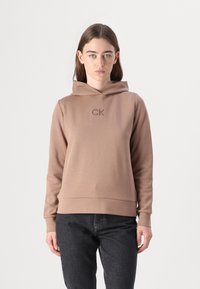 Sudadera con capucha marrón con el logo "CK" del mismo color, hecha de una tela suave, con un corte relajado y puños acanalados.