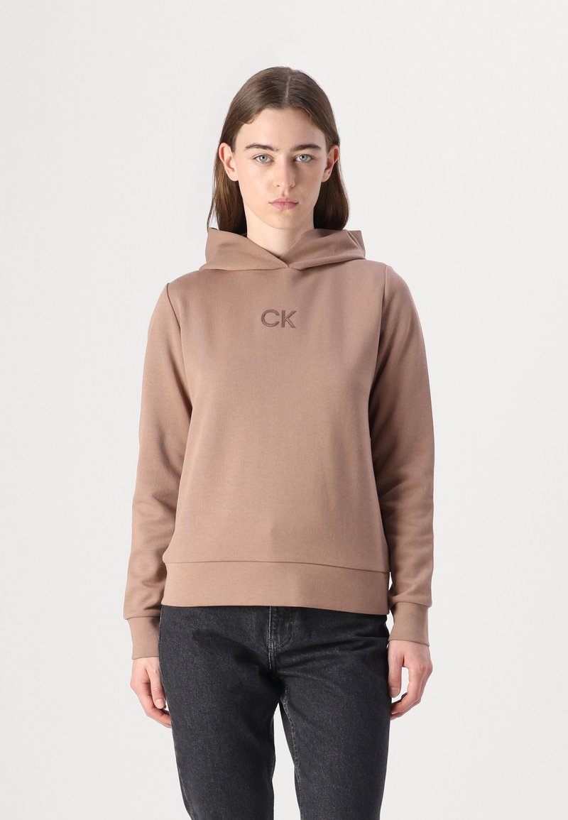 Sudadera con capucha marrón con el logo "CK" del mismo color, hecha de una tela suave, con un corte relajado y puños acanalados.