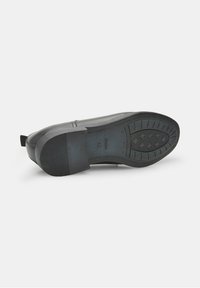 Fekete gumitalp, textúrált tapadás, sima felsőrész és megemelt sarok. Hátsó húzófüllel rendelkezik és 42-es méretjelzéssel ellátott.