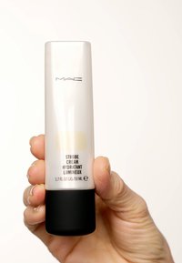 MAC Strobe Cream i en transparent tube med svart bas, 50 mL. Texten inkluderar produktnamn och mått, med en slät yta och minimalistisk design.