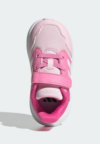 Chaussure de sport rose avec empeigne en mesh, col rembourré, sangle en Velcro et semelle en caoutchouc blanche. Surface texturée avec des accents contrastants.