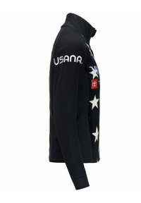 Giacca in pile nera con motivo di stelle bianche. Presenta un colletto alto, tasche con zip e dettagli del logo in bianco e rosso.
