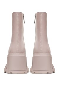 Paire de bottines en daim rose clair avec talons carrés épais et fermetures éclair à l'arrière, vues de dos sur un fond blanc.