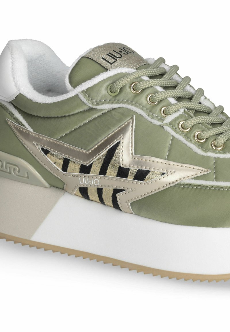 Zapatillas de satén verde con diseño de estrellas doradas y negras, collar acolchado blanco y suela texturizada. Presenta cierre de cordones y logo.