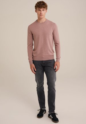 Light pink long-sleeve sweater with a crew neck, paired with dark gray slim-fit jeans and black shoes with white stripes.