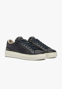 Sneakers in pelle blu navy con suole in gomma bianca. Caratterizzate da punta tonda, chiusura frontale con lacci e interno beige a contrasto. Logo del marchio sul tallone.