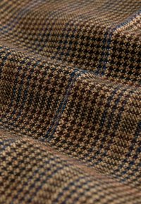 Wool fabric featuring a brown check pattern with blue and red accents. Texture appears soft with a slight sheen, displaying a woven design.