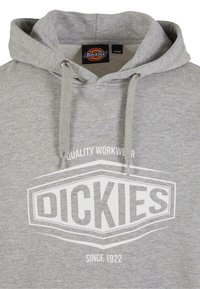 Szürke kapucnis felső, pamut keverék anyagból, nagy fehér logóval, amelyen az áll "DICKIES" és a szöveg "QUALITY WORKWEAR SINCE 1922."