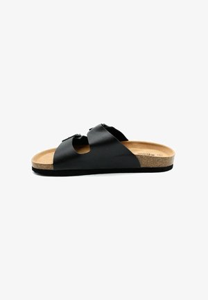 Sandales noires en cuir avec deux larges brides, boucles et une semelle en liège. La semelle est plate avec une finition texturée.