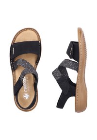Black sandals with a soft, tan footbed. Features adjustable straps in textured gray fabric, stitched accents, and a flexible rubber sole.